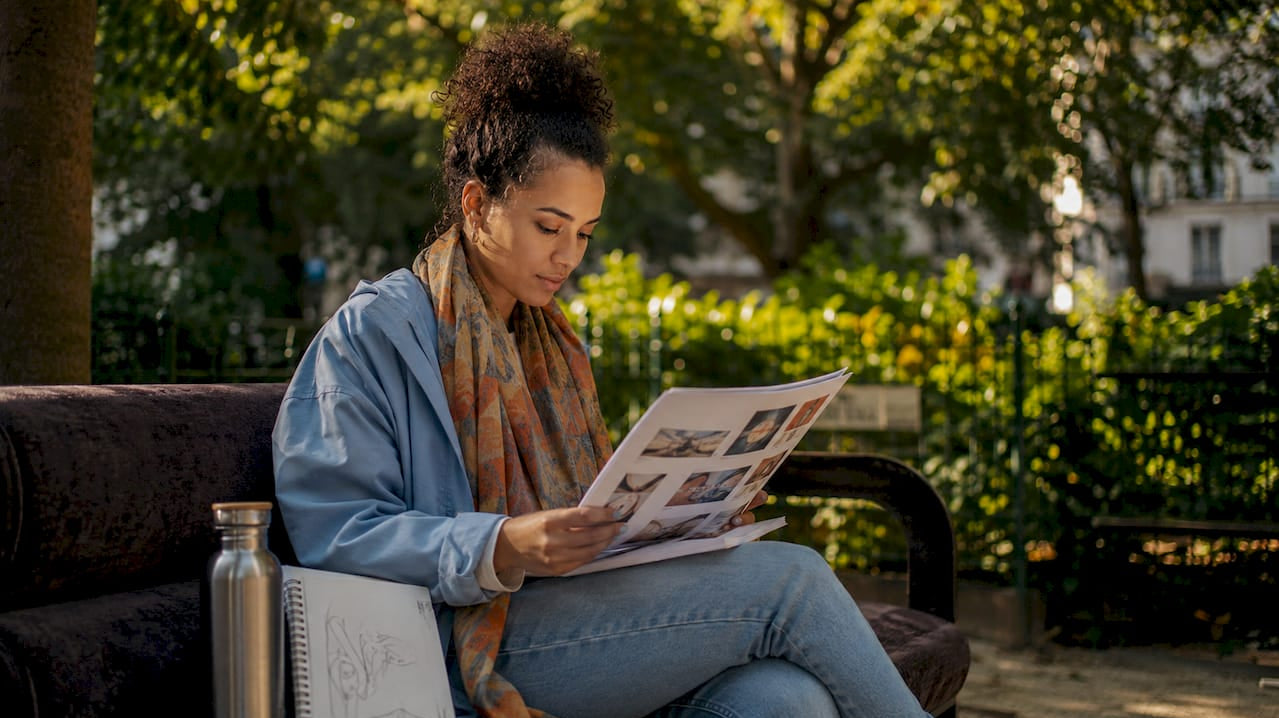 Woman reviewing artist promotion materials in café