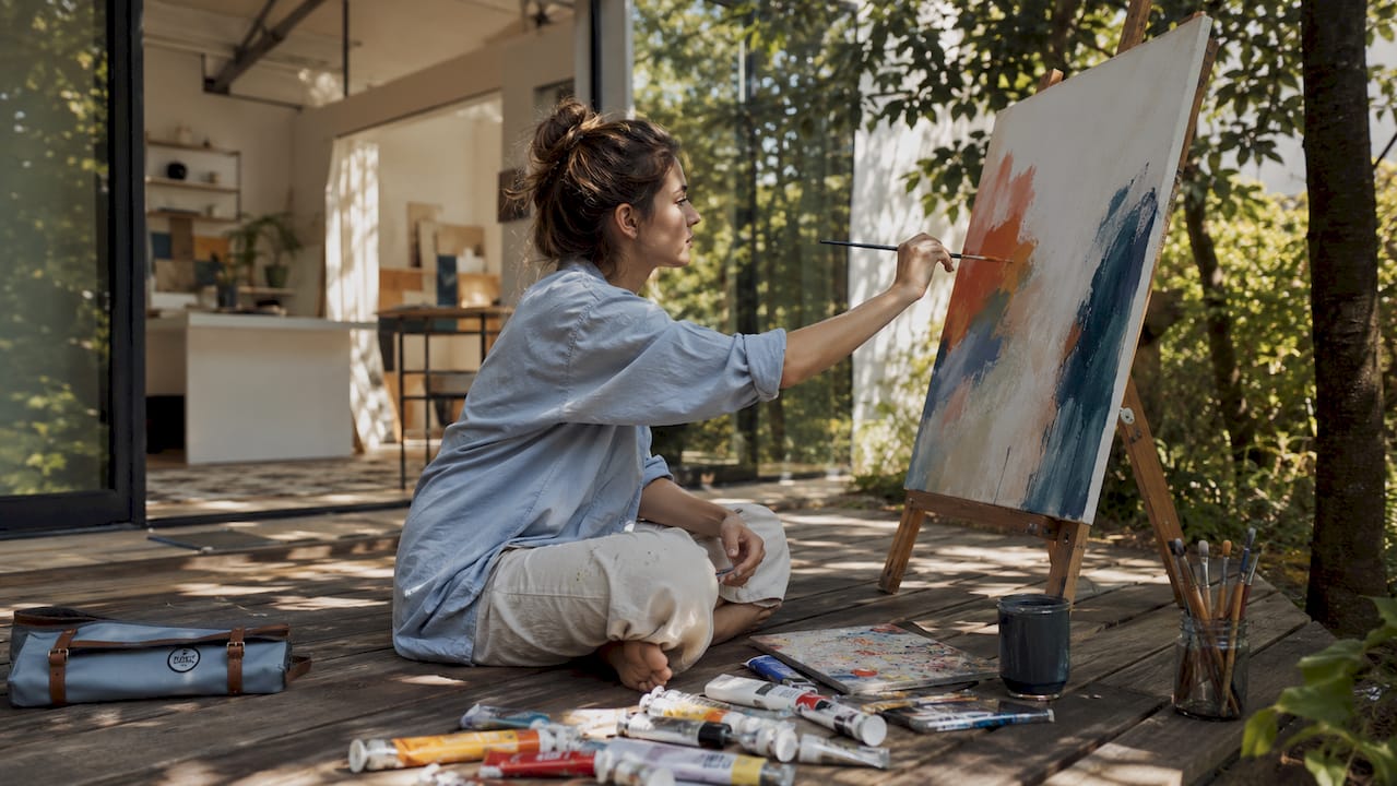 Woman painting in sunlit art studio