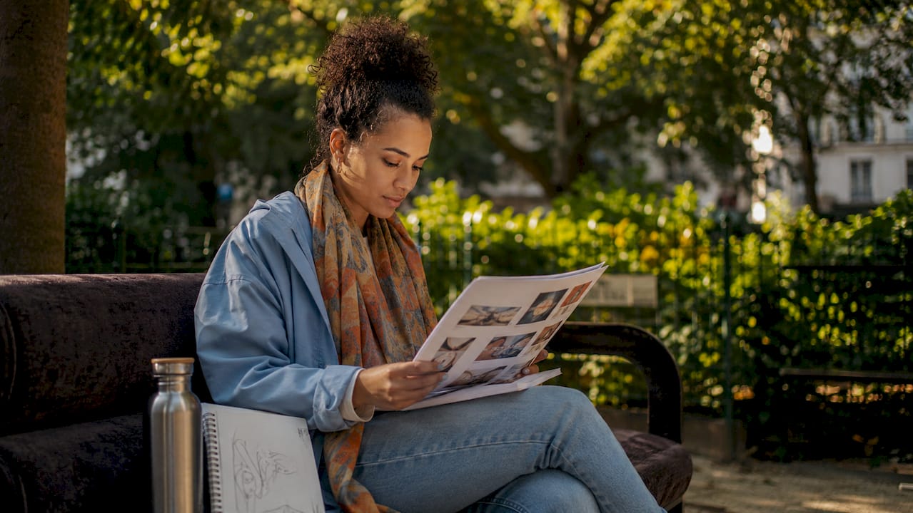 Woman reviewing artist promotion materials in café